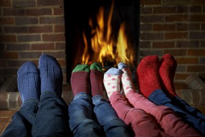 Family Wearing Socks Warming Feet By Fire
