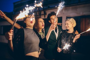 Young people enjoying new years eve with fireworks