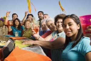 Large Hispanic family toasting at party outdoors