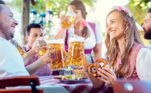 Couple clinking glasses with huge amounts of beer in Bavarian pub