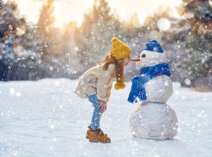 girl playing with a snowman